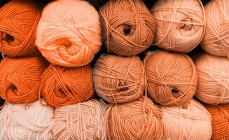 Colorful of Yarn Balls Wool in a Fabric Shop. Background from colored acrylic yarn. Skeins of thread close-up. Materials for needlework, for knitting and crocheting. Mocha Mousse colour of 2024 year photo