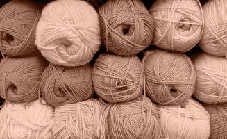 Colorful of Yarn Balls Wool in a Fabric Shop. Background from colored acrylic yarn. Skeins of thread close-up. Materials for needlework, for knitting and crocheting. Mocha Mousse colour of 2024 year photo