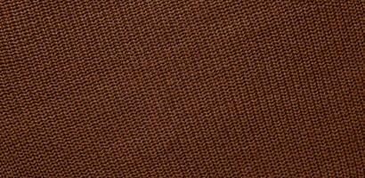Texture of smooth knitted sweater with pattern. Handmade knitting wool or cotton fabric texture. Background of Large knit pattern with knitting needles or crochet. Mocha Mousse colour of 2025 year photo