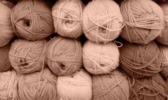 Colorful of Yarn Balls Wool in a Fabric Shop. Background from colored acrylic yarn. Skeins of thread close-up. Materials for needlework, for knitting and crocheting. Mocha Mousse colour of 2024 year photo