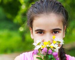 Portrait of little smiling girl with spring flowers bouquet photo