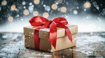 Festive gift box decorated with red bow sits on wooden surface in winter snowfall photo