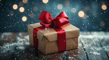 Festive gift box decorated with red bow sits on wooden surface in winter snowfall photo