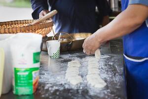 Man making soft dough of chinese doughnut stick before deep-fried. photo