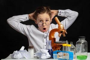 A cute boy chemist suddenly came up with an amazing idea in the laboratory. photo