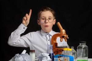 An interesting discovery was made by a little scientist wearing glasses who was studying through a microscope. photo