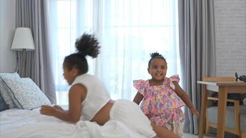 A little girl is playing jump on the bed in the bedroom. photo