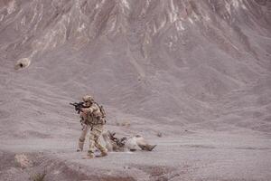 Soldiers in camouflage military uniforms carrying weapons, Reconnaissance missions in rugged mountains, Assault infantry battle training. photo