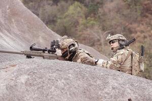 Soldiers in camouflage military uniforms carrying weapons, Reconnaissance missions in rugged mountains, Assault infantry battle training. photo