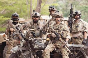 Portrait of soldiers in camouflage uniforms hold weapons in front of a military communication vehicle photo
