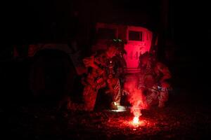 Group of soldiers in camouflage uniforms hold weapons with patrol missions at night photo