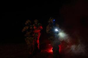 Group of soldiers in camouflage uniforms hold weapons with patrol missions at night photo