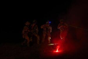 Group of soldiers in camouflage uniforms hold weapons with patrol missions at night photo