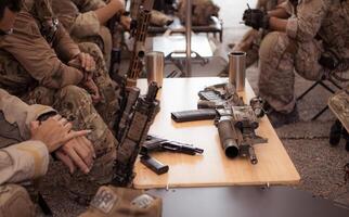 Group of soldiers in camouflage uniforms hold weapons in a field tent, Plan and prepare for combat training. photo