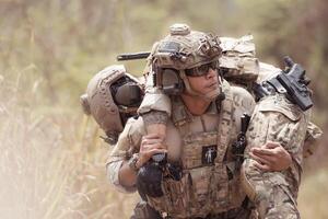 Soldiers in camouflage military uniforms carrying weapons, Reconnaissance missions in the tropical forest area with mission of helping those injured from being shot photo
