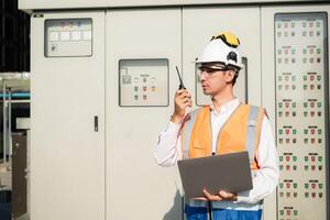 Before proceeding with the testing, Electrical engineer inspects the installed control panel. photo