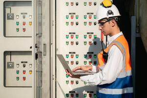 Before proceeding with the testing, Electrical engineer inspects the installed control panel. photo