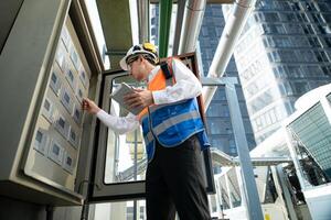 Before proceeding with the testing, Electrical engineer inspects the installed control panel. photo