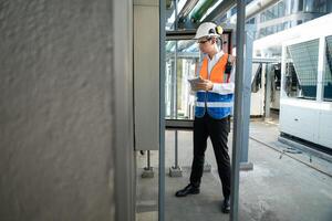 Before proceeding with the testing, Electrical engineer inspects the installed control panel. photo