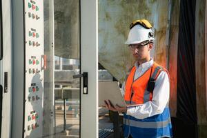 Before proceeding with the testing, Electrical engineer inspects the installed control panel. photo