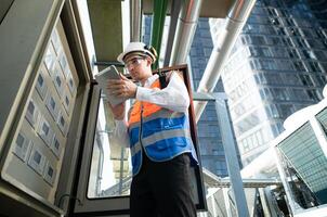 Before proceeding with the testing, Electrical engineer inspects the installed control panel. photo