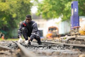 Portrait of a railway engineer on the tracks of a train in station platform. photo