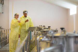 Mature female and male researchers and developers working in winery, Testing wine that has been fermented for a while. photo