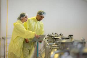 Mature female and male researchers and developers working in winery, Testing wine that has been fermented for a while. photo