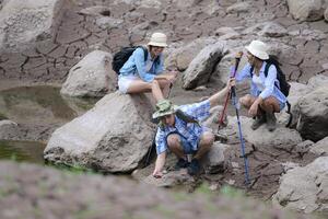 A group of friends going hiking in the streams of the tropical forest area. photo