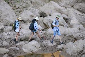 A group of friends going hiking in the streams of the tropical forest area. photo