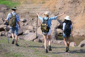 A group of friends going hiking in the streams of the tropical forest area. photo