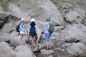 A group of friends going hiking in the streams of the tropical forest area. photo