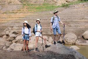 A group of friends going hiking in the streams of the tropical forest area. photo