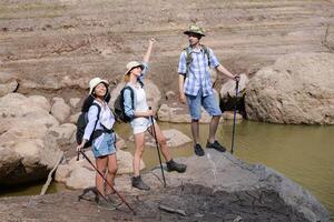 A group of friends going hiking in the streams of the tropical forest area. photo