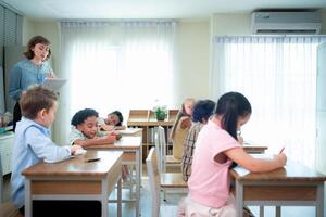 Teacher and students, Learn and study in a classroom of school where youngsters sit and listen attentively. photo