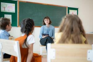 Teacher and students, Learn and study in a classroom of school where youngsters sit and listen attentively. photo