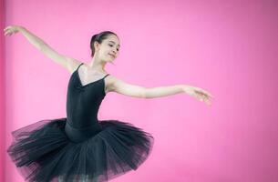 A girl ballet student practices ballet dancing at home with a white background photo