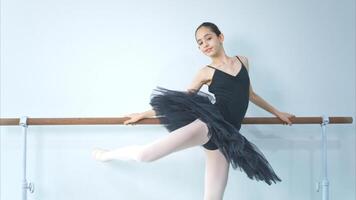 A girl ballet student practices ballet dancing at home with a white background photo