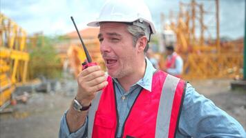 Portrait of crane worker on construction crane use walkie talkie to talk for made to transport the crane from storage to be assembled on the building construction site photo