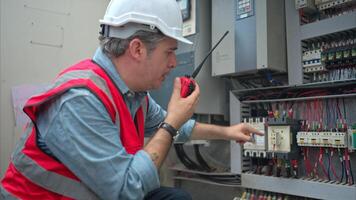 Electrical engineer inspects the electrical control board of a crane before putting it to use on a construction site photo