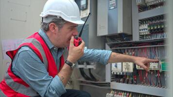 Electrical engineer inspects the electrical control board of a crane before putting it to use on a construction site photo