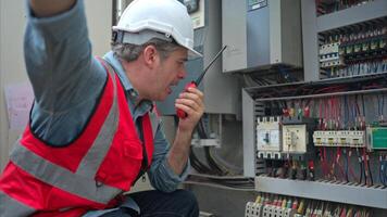 Electrical engineer inspects the electrical control board of a crane before putting it to use on a construction site photo