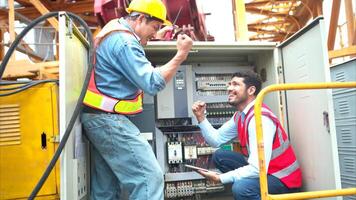 Bothe of electrical engineer inspects the electrical control board of a crane before putting it to use on a construction site photo