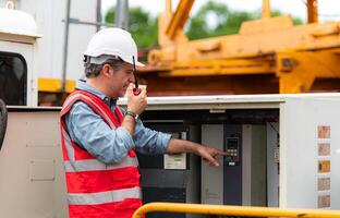 Electrical engineer inspects the electrical control board of a crane before putting it to use on a construction site photo