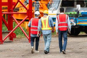 Foreman and worker on construction crane inspection is made to transport the crane from storage to be assembled on the building construction site photo