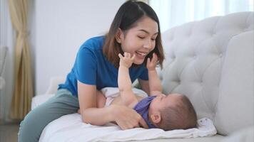 A tiny child happily on the sofa waiting for mother put on clothes photo