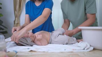 A tiny child happily on the towel waiting for parents apply powder and put on clothes after taking a bath photo