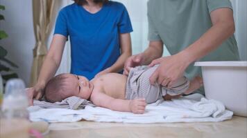 A tiny child happily on the towel waiting for parents apply powder and put on clothes after taking a bath photo