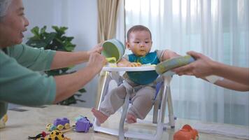un pequeño niño comiendo su primero comida, madre y abuela animar emocionado foto