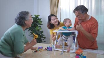 un pequeño niño comiendo su primero comida, padres y abuelos animar emocionado foto